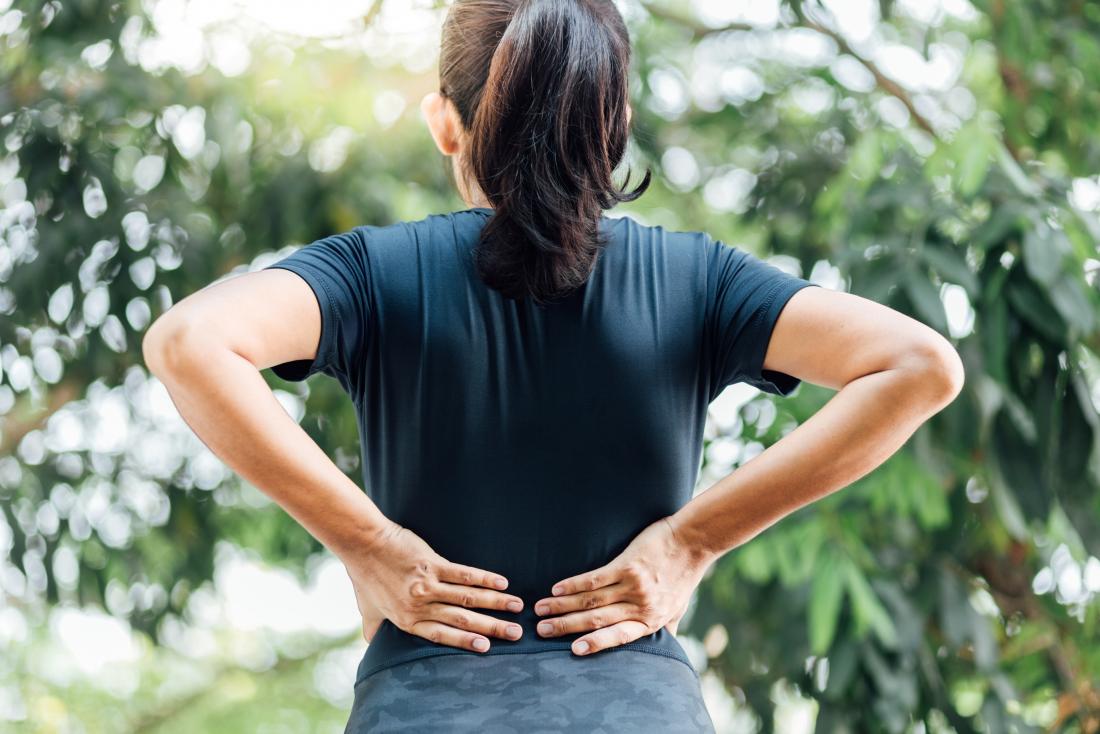 Woman holding her back due to lower back and hip pain