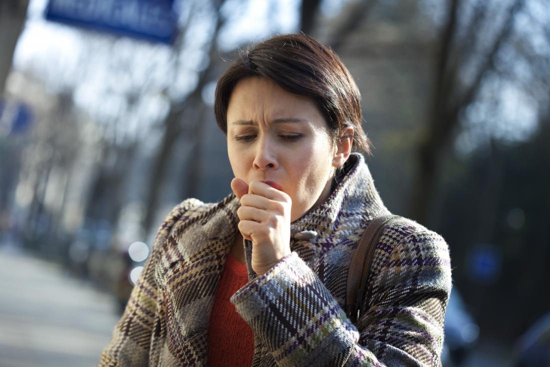Woman with brittle asthma coughing into hand