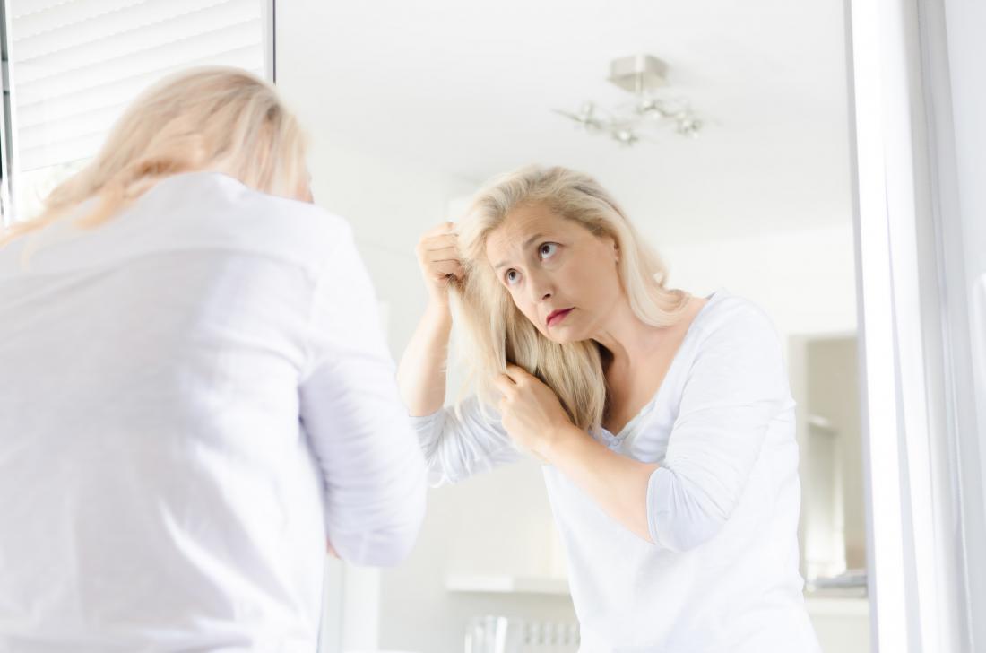 Woman touching hair due to adderall hair loss