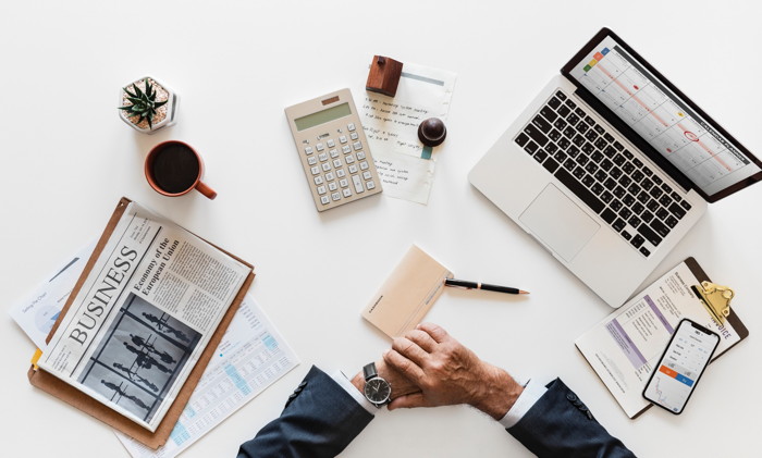 man in front of laptop, calculator, and papers - Photo by rawpixel on Unsplash