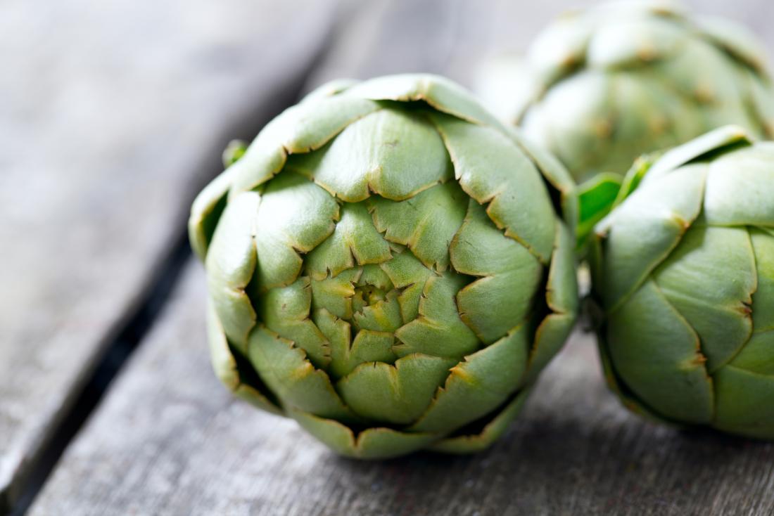 Artichokes on wooden surface