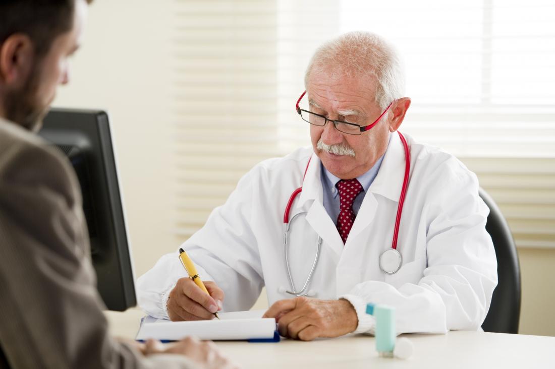 doctor and male patient with inhaler on table