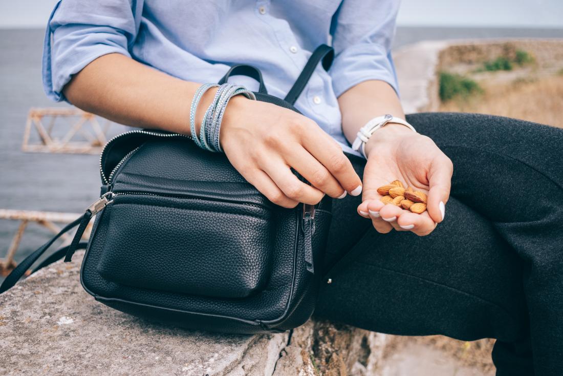 A person outside havin<em></em>g almond nuts as a snack.