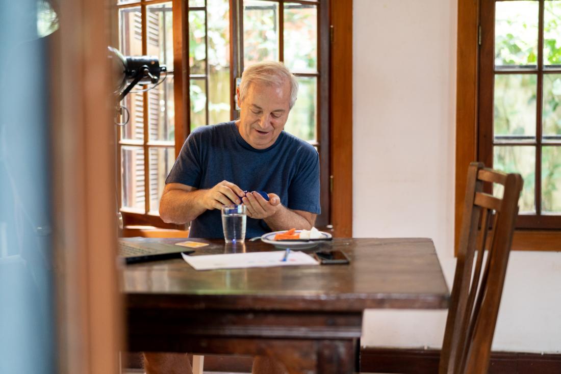 senior man taking medication while eating lunch