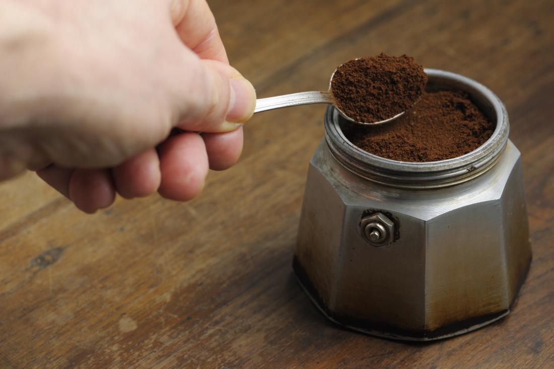 person spoo<em></em>ning coffee grounds
