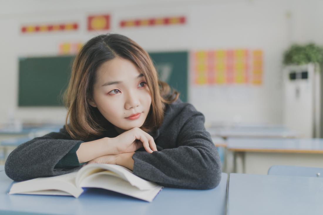young woman daydreaming in class